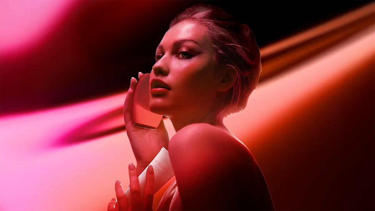 A woman using LUNA 4 face brush  